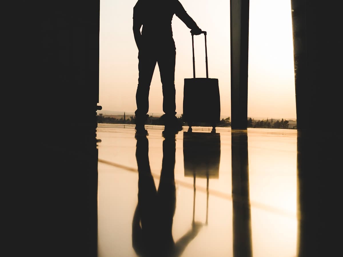 Traveller with luggage watching a plane depart